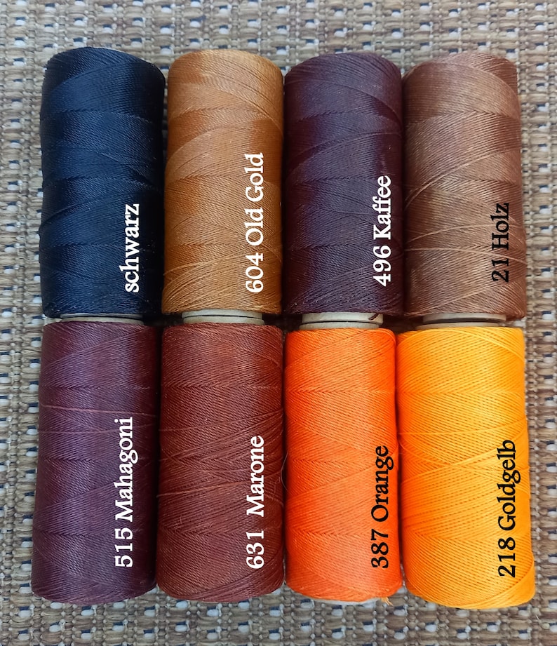 Pode incluir: Oito carret&eacute;is de fio encerado em v&aacute;rios tons de marrom, laranja e preto. Os carret&eacute;is s&atilde;o etiquetados com n&uacute;meros e palavras alem&atilde;s para as cores, incluindo "Mahagoni", "Marone", "Old Gold", "Kaffee", "Goldgelb", "Holz" e "Schwarz".