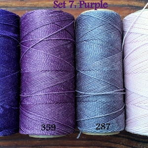 Puede incluir: Cuatro carretes de hilo de bordar en tonos de morado, azul y rosa. Los carretes est&aacute;n etiquetados con los n&uacute;meros: 369, 359, 287 y 239. El texto "Set 7: Purple" es visible en la parte superior de la imagen.