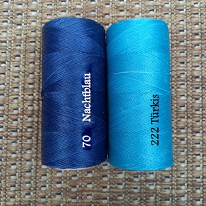 May include: Two spools of thread, one dark blue and one turquoise. The dark blue spool has the text "70 Nachtblau" printed on it. The turquoise spool has the text "222 T&uuml;rkis" printed on it.