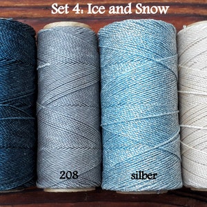 Puede incluir: Conjunto de cuatro carretes de hilo de bordar en tonos de azul, gris y blanco. Los carretes est&aacute;n etiquetados con 209, 208, silber y 548. El conjunto se titula "Set 4: Ice and Snow".