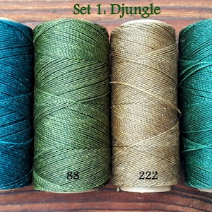 Puede incluir: Conjunto de cuatro carretes de hilo de bordar en tonos de verde, verde azulado y beige. Los carretes est&aacute;n etiquetados con los n&uacute;meros 386, 88, 222 y 367. El texto "Set 1. Djungel" es visible en la parte superior de la imagen.