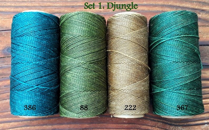 Puede incluir: Conjunto de cuatro carretes de hilo de bordar en tonos de verde, verde azulado y beige. Los carretes est&aacute;n etiquetados con los n&uacute;meros 386, 88, 222 y 367. El texto "Set 1. Djungel" es visible en la parte superior de la imagen.