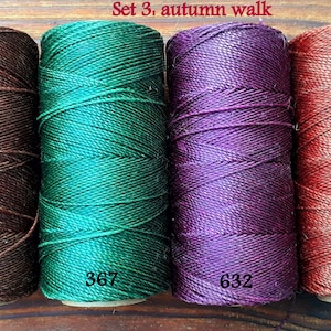Puede incluir: Conjunto de cuatro carretes de hilo de bordar en tonos marr&oacute;n, verde, morado y rojo. Los carretes est&aacute;n etiquetados con los n&uacute;meros 515, 367, 632 y 25. El texto "Set 3. autumn walk" est&aacute; escrito encima de los carretes.