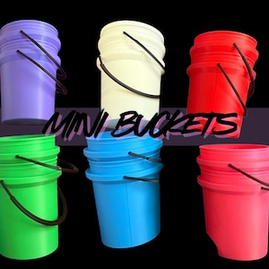 May include: A collection of six mini buckets in various colors: purple, white, red, green, blue, and pink. Each bucket has a black handle and the text "MINI BUCKETS" is displayed across the image.
