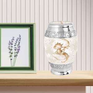 Baby dragon urn displayed on a wooden shelf next to a lavender photo frame, showcasing a beautiful and personalized memorial piece for home décor.