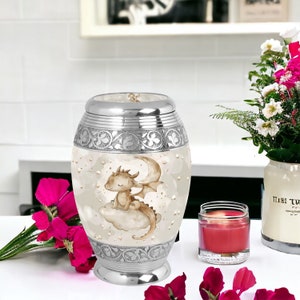 Baby dragon urn beautifully placed among flowers and a candle, providing a serene and elegant memorial for a loved one. Perfect for home display or memorial services.