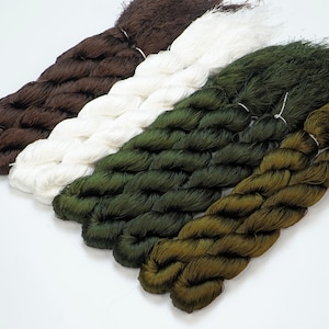 May include: Four spools of thread in different colors: brown, white, dark green, and olive green. The thread is twisted and has a fuzzy texture.