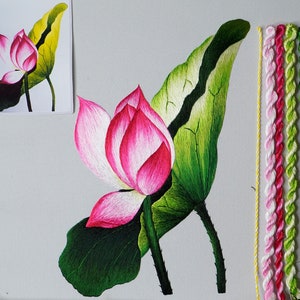 May include: Embroidery project featuring a pink and white lotus flower with green leaves. The embroidery is done on white fabric and uses a variety of colored threads.
