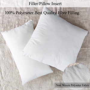 May include: Two white pillow inserts made of 100% polyester fiber filling. The pillow inserts are on a beige fabric surface. The text "Filler/Pillow Insert" and "100% Polyeseter Best Quality Fibre Filling" is at the top of the image. The text "Non Woven Polyseter Fabric" is at the bottom of the image.