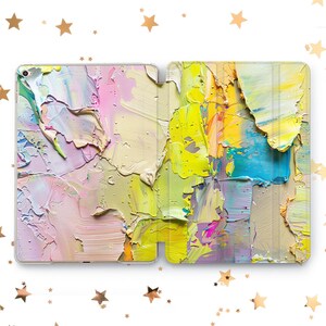 May include: A tablet case featuring a colorful abstract oil painting design. The artwork showcases thick brushstrokes in shades of yellow, pink, blue, and beige, creating a textured appearance. The case is designed to protect the tablet while adding an artistic flair.