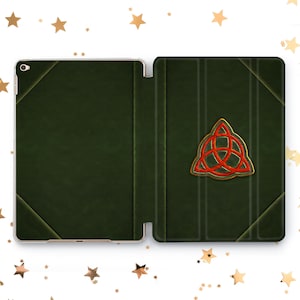 May include: A green leather iPad case with a gold and red triquetra symbol on the front.