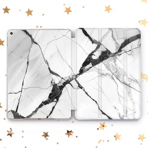 May include: A white iPad case with a black marble pattern. The case is made of a durable material and has a sleek design.