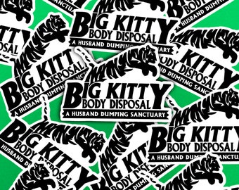 以下が含まれることがあります： 緑色の背景に、「Big Kitty Body Disposal A Husband Dumping Sanctuary」というテキストが書かれた黒と白のステッカーがいくつかある、クローズアップ写真です。