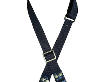 May include: A black adjustable bag strap with metal hardware. The strap features a rectangular buckle, metal clasps, and leather accents. The strap is designed to be attached to a bag or purse.