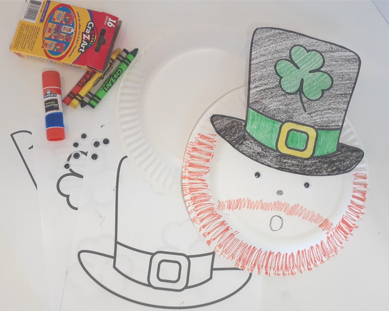 May include: A paper plate craft project to make a leprechaun. The paper plate is decorated with red, green, and black markers. The leprechaun has a black hat with a green shamrock on top, a green band around the hat, and a red beard. The leprechaun has googly eyes and a white mouth.