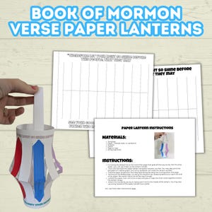 May include: A handmade paper lantern with red, blue, and purple accents, held by a hand. The lantern has a white handle and is decorated with text. Accompanying the lantern are instructions and templates for making the lantern.