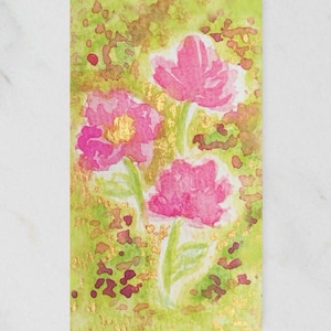 May include: Watercolor painting of three pink flowers with gold accents on a green and yellow background. The flowers have detailed petals and green stems. The artwork has a soft, artistic style, suitable for floral art prints and cards.