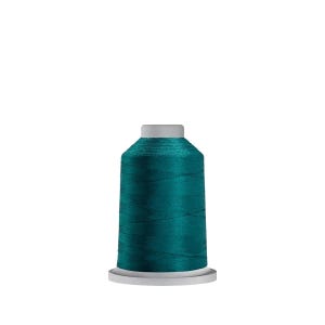 May include: A spool of teal thread on a white bobbin.