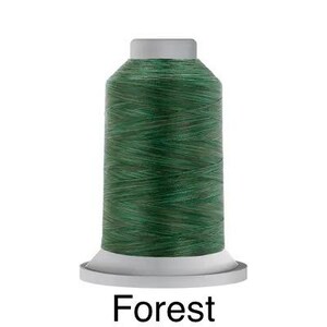May include: A spool of green thread with a white label that says "Forest".