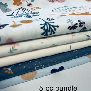 May include: A stack of five fabric pieces, each with a unique pattern. The top layer features a white background with floral and woodland illustrations in muted colors. The text "5 pc bundle 1/2 yard pcs." is visible.