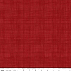 May include: Close-up of red fabric with a textured, crosshatch pattern. The fabric is a solid, deep red color. A ruler with inch measurements is at the bottom of the image.