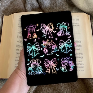 Op de afbeelding: Een zwarte tablethoes met een neon ontwerp van Halloween geesten, strikken, vleermuizen en sterren. De geesten dragen hoeden en houden pompoenen vast. Het ontwerp staat tegen een zwarte achtergrond.