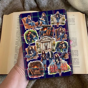 Könnte beinhalten: Ein Stickerbogen in Marineblau und Grün mit verschiedenen Aufklebern. Die Aufkleber zeigen Menschen beim Lesen, Gebäude und Bücherstapel. Die Illustrationen haben ein gemütliches, akademisches Thema.