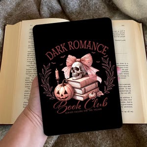 Op de afbeelding: Zwart rechthoekig boekenclubontwerp met de tekst "DARK ROMANCE BOOK CLUB" en een illustratie van een schedel, strik, pompoen en boeken. De tekst "ALWAYS FALLING FOR THE VILLAIN" is ook opgenomen.
