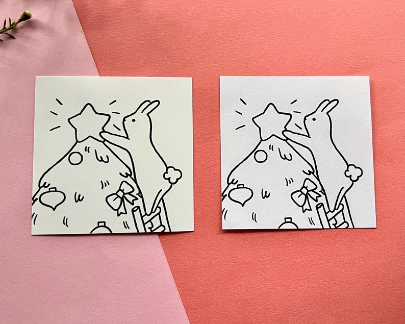 May include: Two black and white illustrations of bunnies decorating a Christmas tree. One bunny is placing a star on top of the tree, while the other bunny is holding a ribbon.