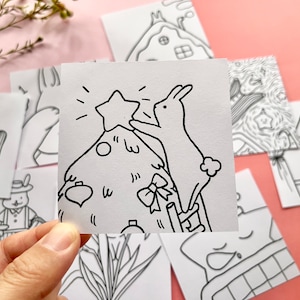 May include: A black and white line drawing of a rabbit decorating a Christmas tree with a star on top. The rabbit is standing on a ladder.