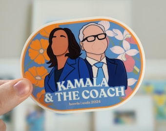 May include: Oval sticker with a blue background featuring illustrations of Kamala Harris and a man in suits. The sticker has orange and white flowers around the border. The text on the sticker reads "Kamala & The Coach" and "harris | waltz 2024".
