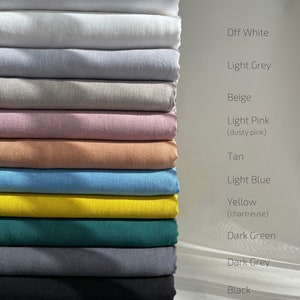 May include: A stack of 14 fabric swatches in various colors, including white, off-white, light grey, beige, light pink, tan, light blue, yellow, dark green, dark grey, black, and red tartan.
