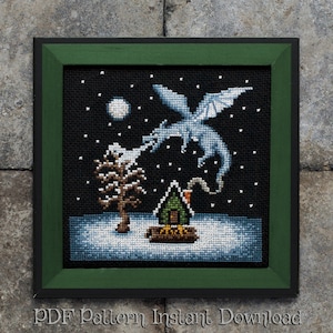 Könnte beinhalten: Ein Kreuzstichmuster mit einem weißen Drachen, der Rauch auf ein kleines grünes Haus in einer verschneiten Landschaft bläst. Der Drache fliegt im Nachthimmel mit einem Vollmond im Hintergrund. Das Muster ist in einem dunkelgrünen Rahmen mit einem schwarzen Außenrahmen gerahmt.