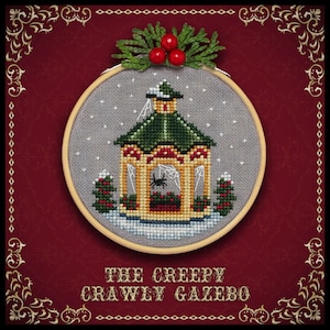 May include: A cross-stitch embroidery of a creepy crawley gazebo with a spider web and a spider inside. The gazebo is decorated with holly and snow. The embroidery is framed in a wooden hoop and has a red background with gold trim.