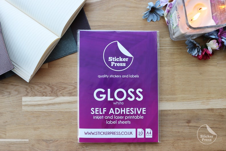 May include: A package of 10 sheets of white gloss self-adhesive sticker paper. The paper is inkjet and laser printable. The package is labeled "Sticker Press" and "Gloss white" and includes the website "www.stickerpress.co.uk".