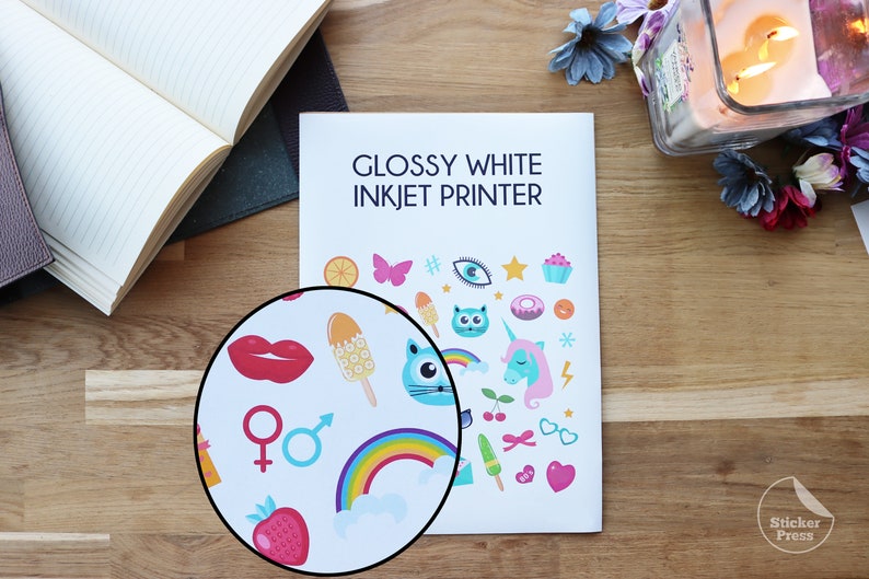 May include: Glossy white inkjet printer paper with a sheet of colorful stickers printed on it. The stickers feature a variety of fun and whimsical designs, including a rainbow, a unicorn, a cat, a cupcake, and a strawberry.