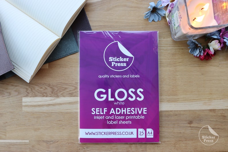 May include: A package of 25 sheets of white gloss self-adhesive inkjet and laser printable label sheets. The package is purple with the text "Sticker Press" and "quality stickers and labels". The package also says "GLOSS white SELF ADHESIVE inkjet and laser printable label sheets WWW.STICKERPRESS.CO.UK 25 A4"