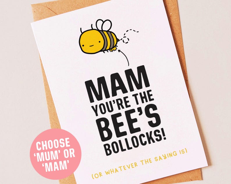 Peut inclure: Une carte blanche avec une illustration de dessin anim&eacute; d'abeille noire et jaune. La carte dit "MAM YOU'RE THE BEE'S BOLLOCKS! (OR WHATEVER THE SAYING IS)" et a un cercle rose avec le texte "CHOOSE 'MUM' OR 'MAM'" dans le coin inf&eacute;rieur gauche.