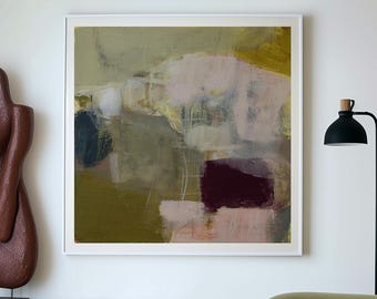 May include: A modern living room featuring an abstract painting in a white frame, a green sofa, and a round coffee table with a patterned top. A wooden sculpture and a black lamp add to the room's decor. The room has a neutral color palette.