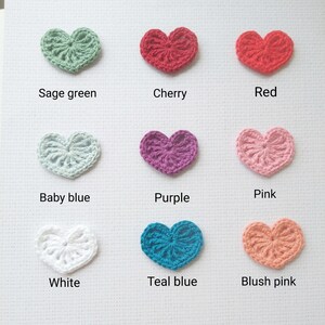 May include: Nine crocheted hearts in different colors: sage green, cherry, red, baby blue, purple, pink, white, teal blue, and blush pink.
