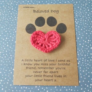 May include: A brown card with the text "Beloved Dog" and a black paw print with a pink crocheted heart on top. The card reads "A little heart of love I send as I know you miss your faithful friend, remember you're never far apart your little friend lives in your heart x."