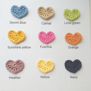 May include: Nine crocheted hearts in different colors: denim blue, camel, lime green, sunshine yellow, fuchsia, orange, heather, yellow, and navy.