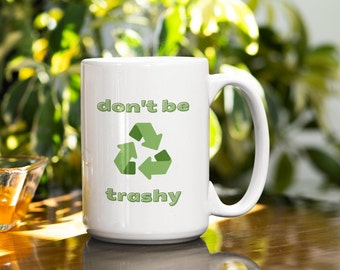 May include: White ceramic mug with a green recycle symbol and the text "don't be trashy" in green letters.