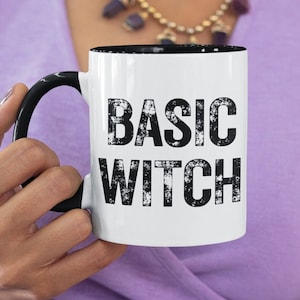 May include: White ceramic mug with a black handle and black text that reads "Basic Witch".