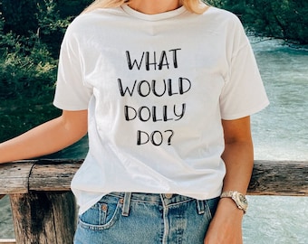 May include: White t-shirt with black text that reads "What Would Dolly Do?"