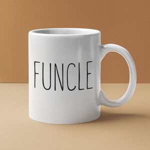 May include: White ceramic mug with a black inscription that reads "FUNCLE".