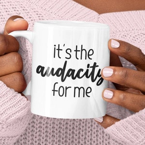 May include: White ceramic mug with black text that reads "it's the audacity for me".