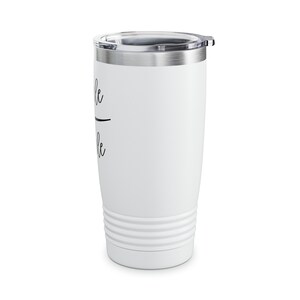 May include: White stainless steel tumbler with a black inscription that reads "remarkable". The tumbler has a lid and a double-walled design.
