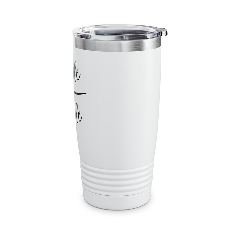 May include: White stainless steel tumbler with a black inscription that reads "remarkable". The tumbler has a lid and a double-walled design.