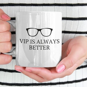 May include: White ceramic mug with a black silhouette of eyeglasses and the text "VIP is always better".